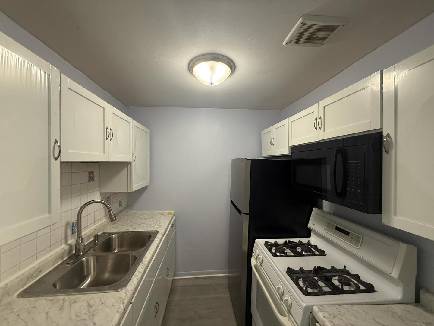 1195 Meadow Lane, Unit 114 Hoffman Estates, IL 60169 - Photo 3 of 5 a kitchen with a sink stove and refrigerator