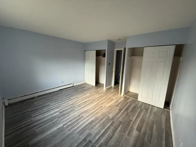 an empty room with wooden floor and entrance