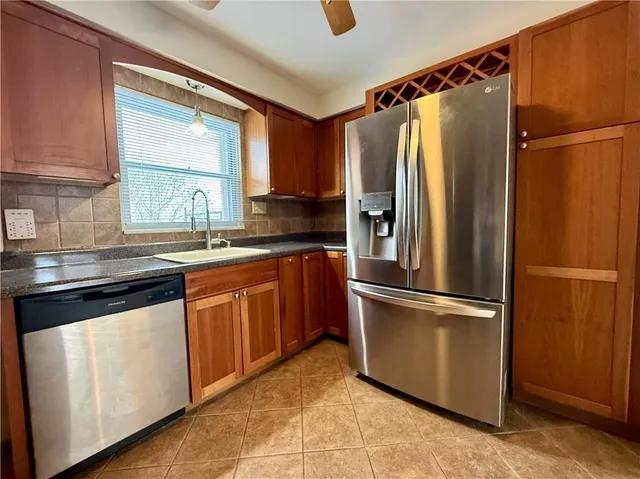 a kitchen with stainless steel appliances granite countertop a refrigerator and a sink