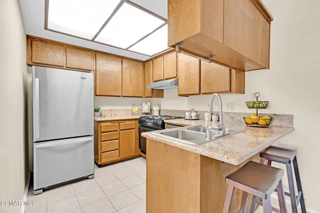 a kitchen with granite countertop a sink and a wooden cabinets