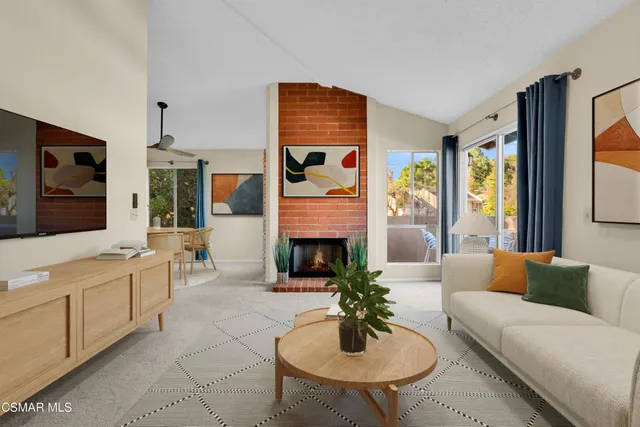 a living room with furniture fireplace and a large window