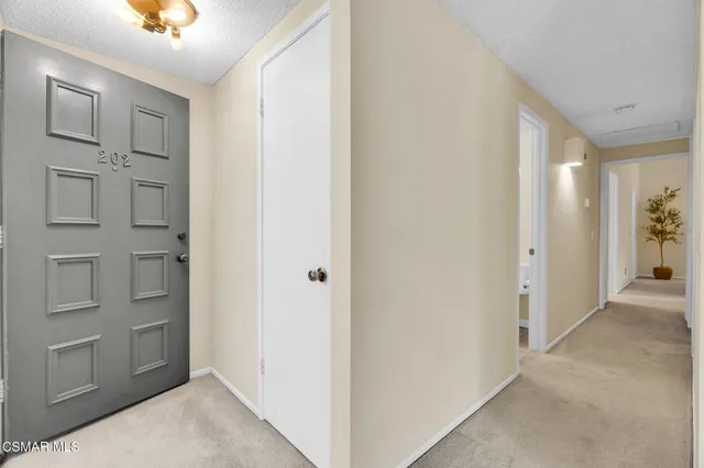 a view of a hallway with closet and wooden floor