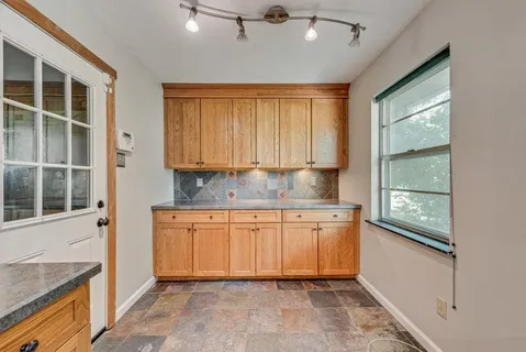 a kitchen with granite countertop a stove and white cabinets