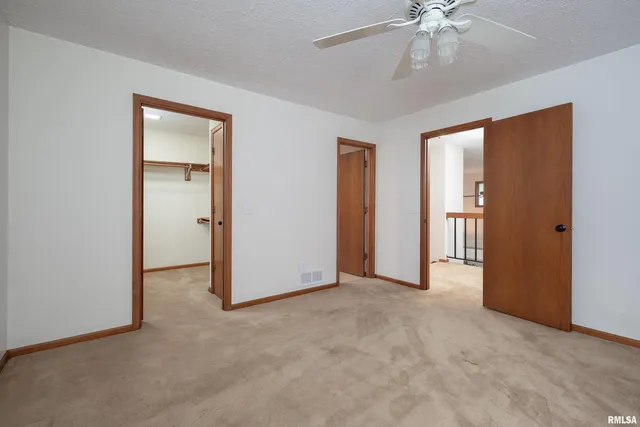 a view of empty room with window and ceiling fan