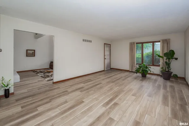 a view of a livingroom with wooden floor and a potted plant