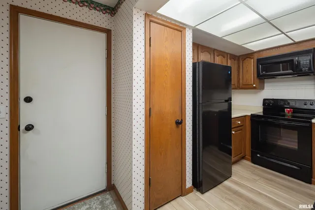 a kitchen with a refrigerator cabinet and a microwave