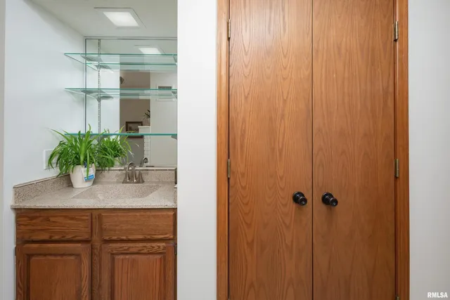 a bathroom with a granite countertop sink a mirror and a shower