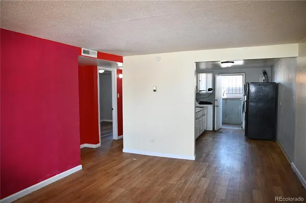 a kitchen with furniture a refrigerator and a view of living room