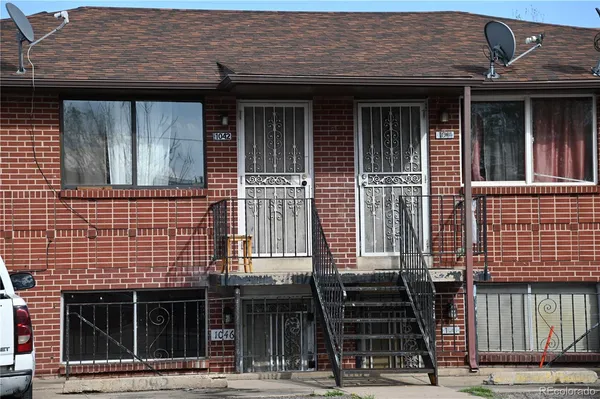 a front view of a building with a garden