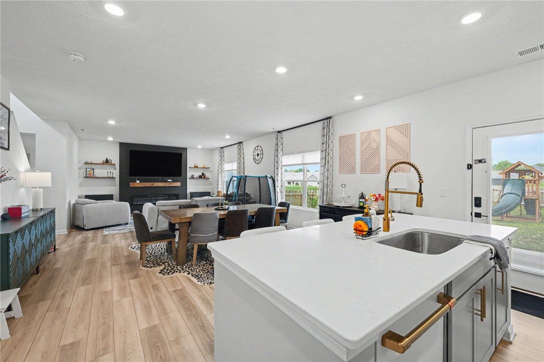 3011 Falls Road Clayton, OH 45315 - Photo 28 of 66 A golden faucet highlights the spacious kitchen island, opening to a sun-filled living area and outdoor play space.