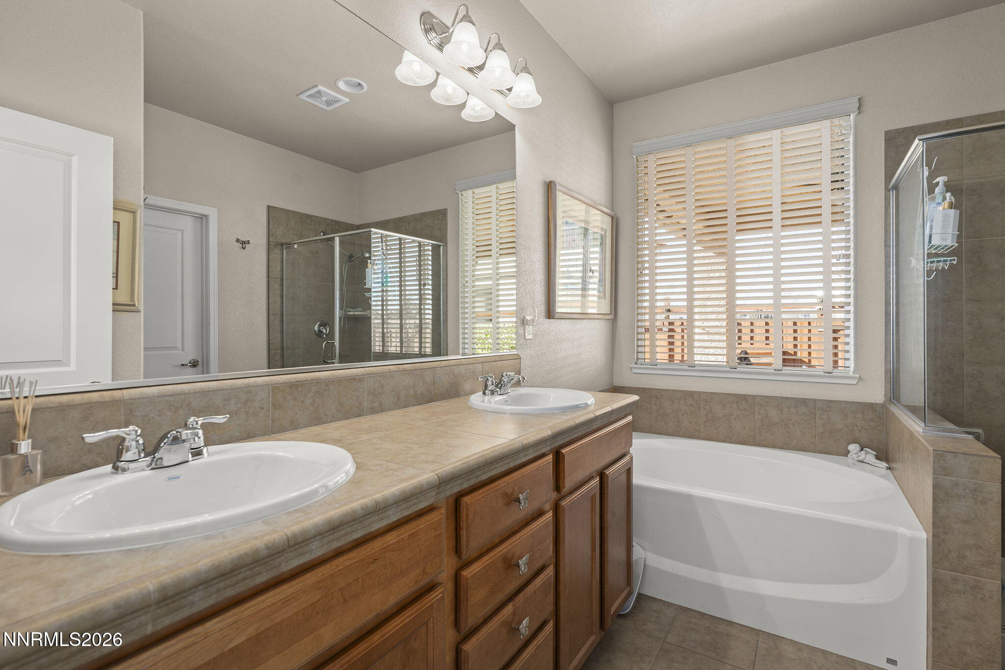 6787 Centaurus Drive Sparks, NV 89436 - Photo 13 of 39 a bathroom with a granite countertop sink a large mirror a bathtub and next to a window