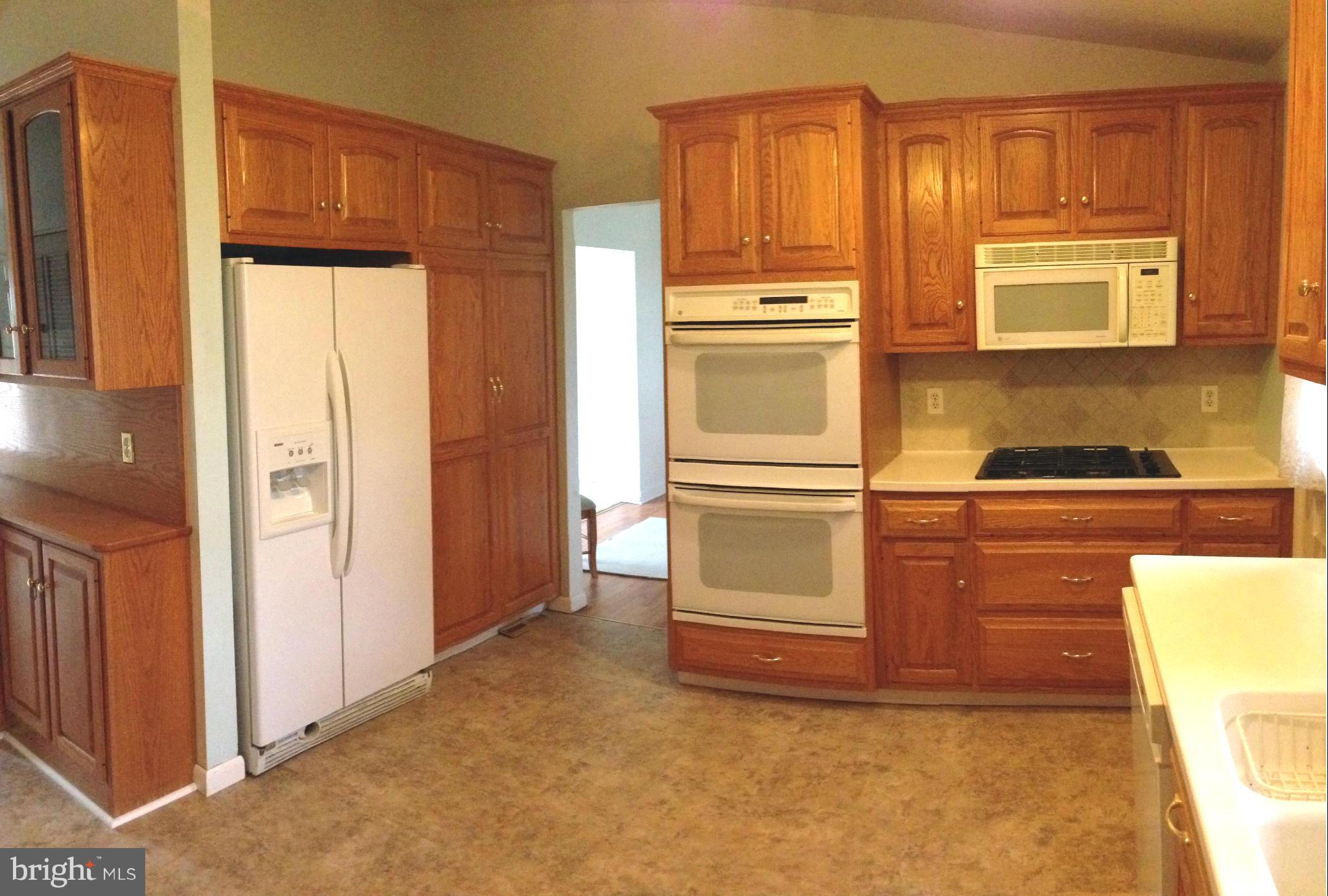1616 Hopefield Road Silver Spring, MD 20905 - Photo 5 of 22 a kitchen with white cabinets and a refrigerator