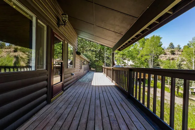 a view of a balcony with furniture and wooden floor
