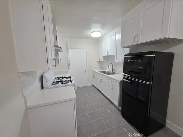 a kitchen with a stove a refrigerator and a sink