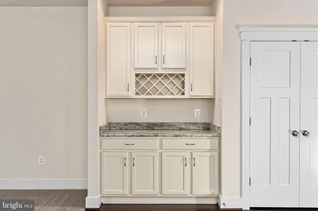 a view of an empty room with wooden floor and window
