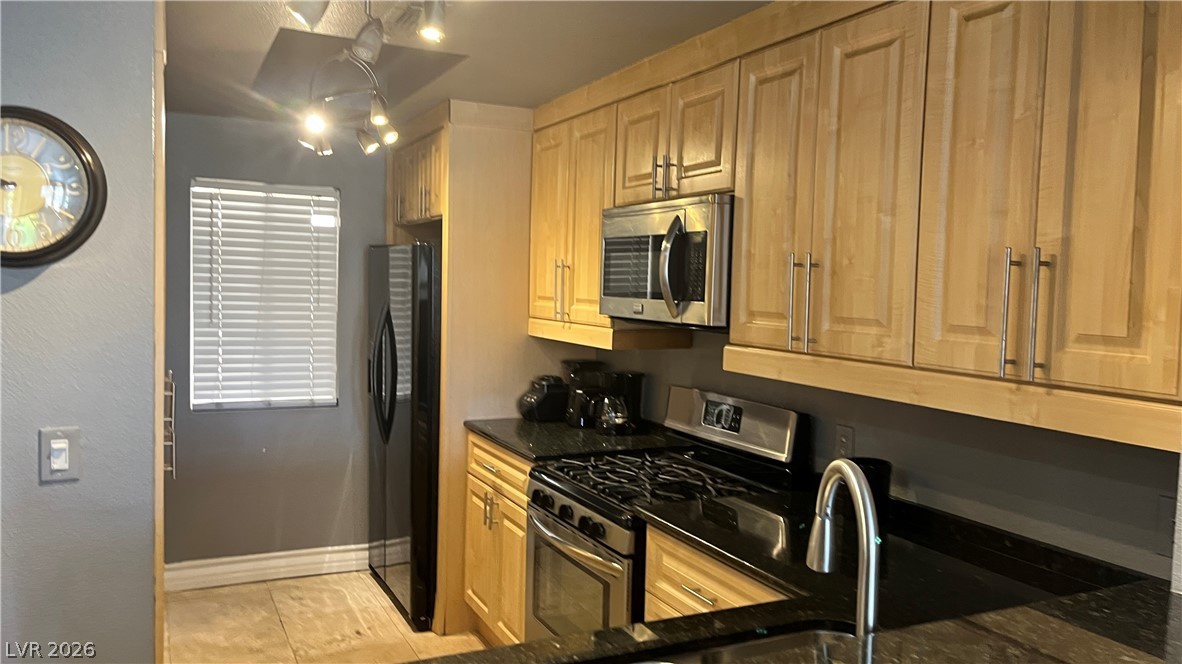 210 East Flamingo Road, Unit 205 Las Vegas, NV 89169 - Photo 8 of 17 Culinary adventures await in this kitchen, boasting black granite counters and contemporary wooden cabinetry.