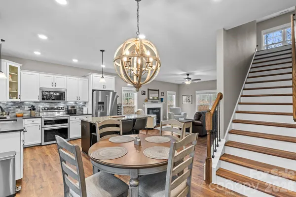 a view of a dining room with furniture a kitchen and chandelier