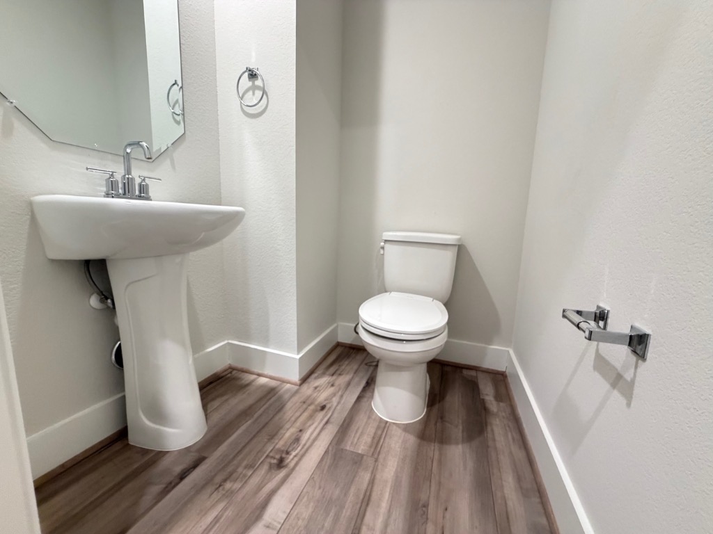 7417 Acela Trail, Unit 231 Austin, TX 78744 - Photo 3 of 15 Half bath featuring light wood-type flooring and a textured wall