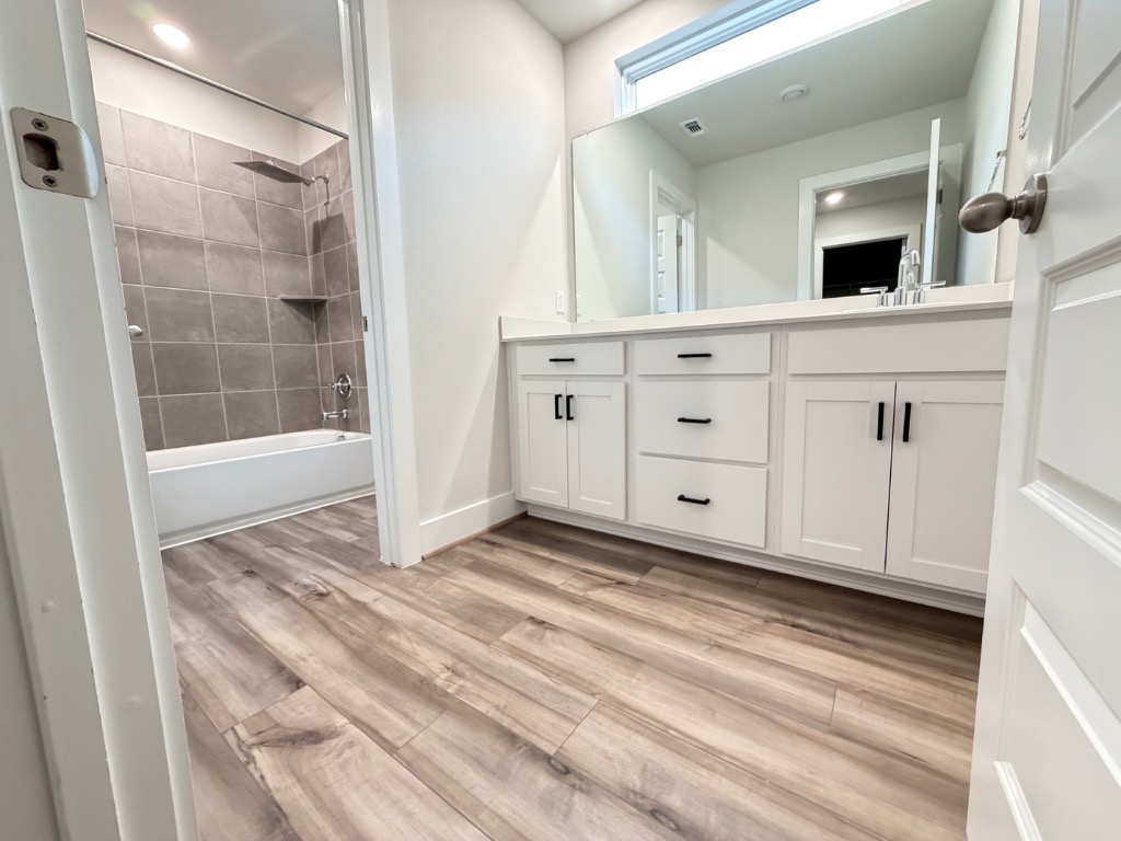 7417 Acela Trail, Unit 231 Austin, TX 78744 - Photo 9 of 15 Full bathroom with double vanity, shower / bathtub combination, and light wood-style floors