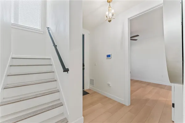 a view of a hallway with wooden floor and entryway