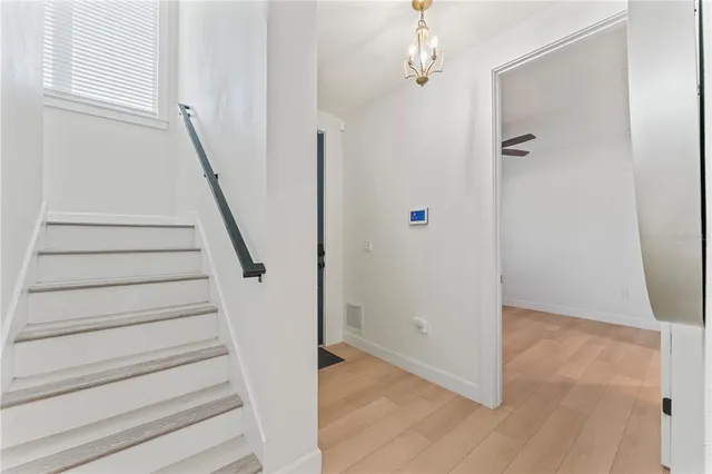 a view of a hallway with wooden floor and entryway