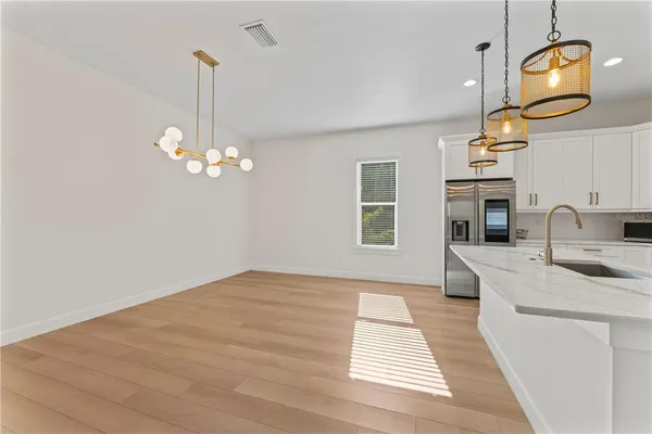 a large white kitchen with a large island oven a stove and a refrigerator