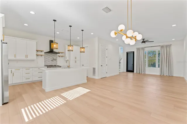 a view of a room with wooden floor and chandelier