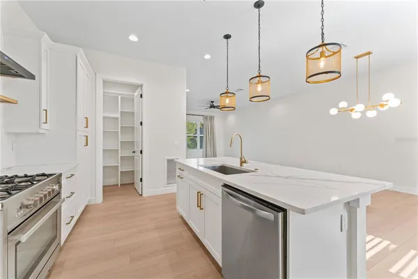 a kitchen that has a lot of cabinets and wooden floor