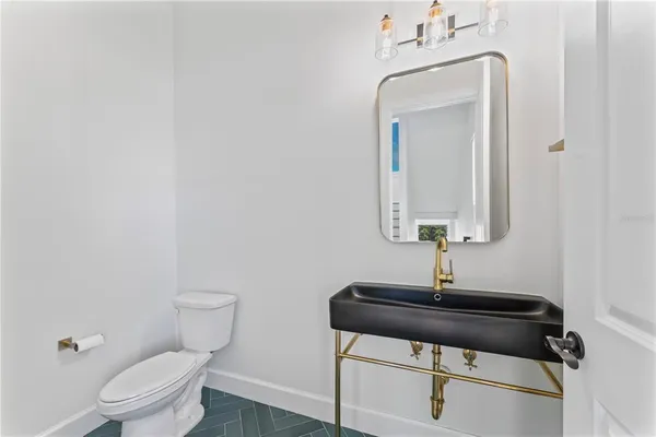 a bathroom with a toilet a sink and mirror