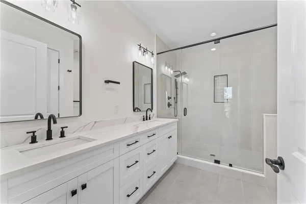 a bathroom with a double vanity sink mirror double and shower