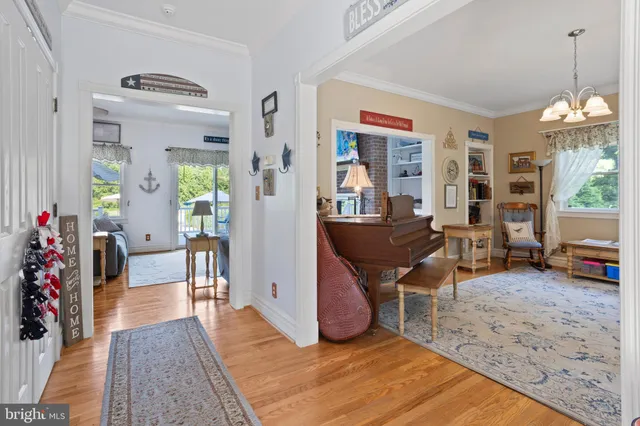 a dining room with wooden floor and a chandelier