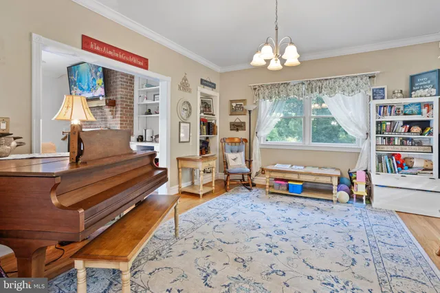 a reading room with furniture a window and a chandelier