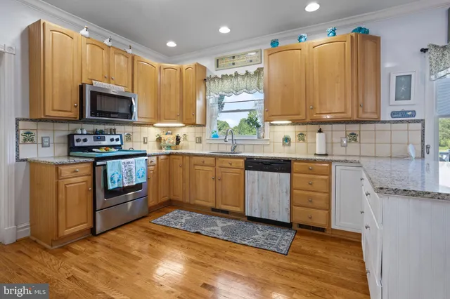 a kitchen with stainless steel appliances granite countertop a sink stove and microwave