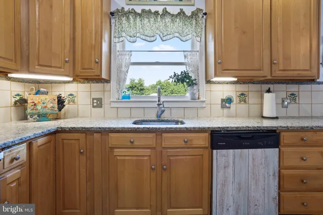 a kitchen with stainless steel appliances granite countertop a sink and cabinets with wooden floor