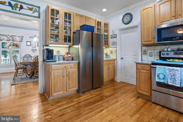 a kitchen with granite countertop a refrigerator and a stove top oven
