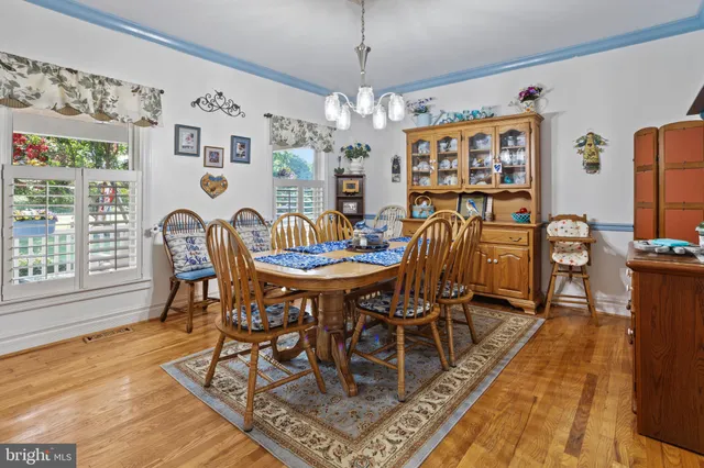 a dining room with furniture a chandelier and wooden floor