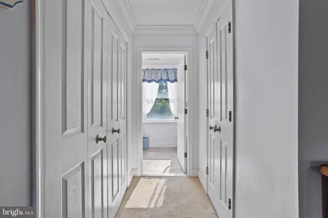 a view of a hallway with a livingroom and a bathroom