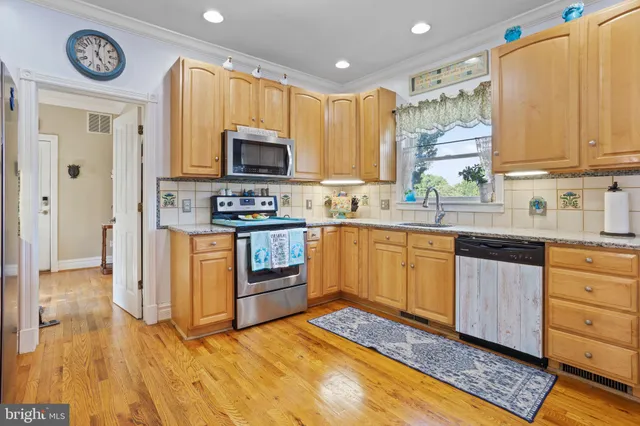 a kitchen with granite countertop a stove a sink and a microwave