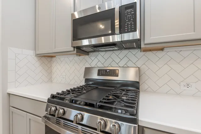 a stove top oven sitting inside of a kitchen