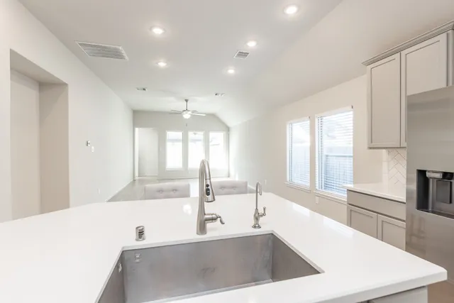a view of a kitchen with a sink a large window and stainless steel appliances
