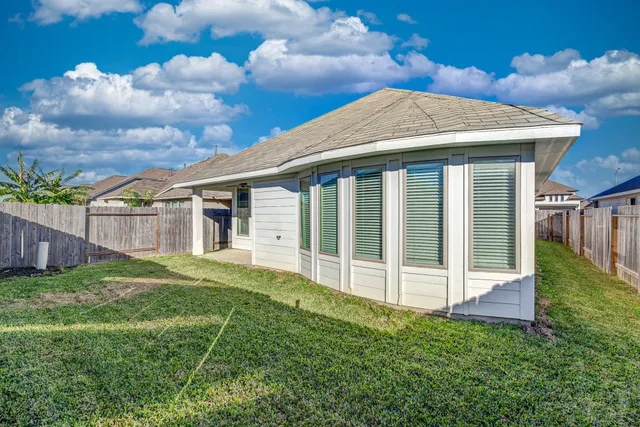 a view of a house with a yard and wooden fence