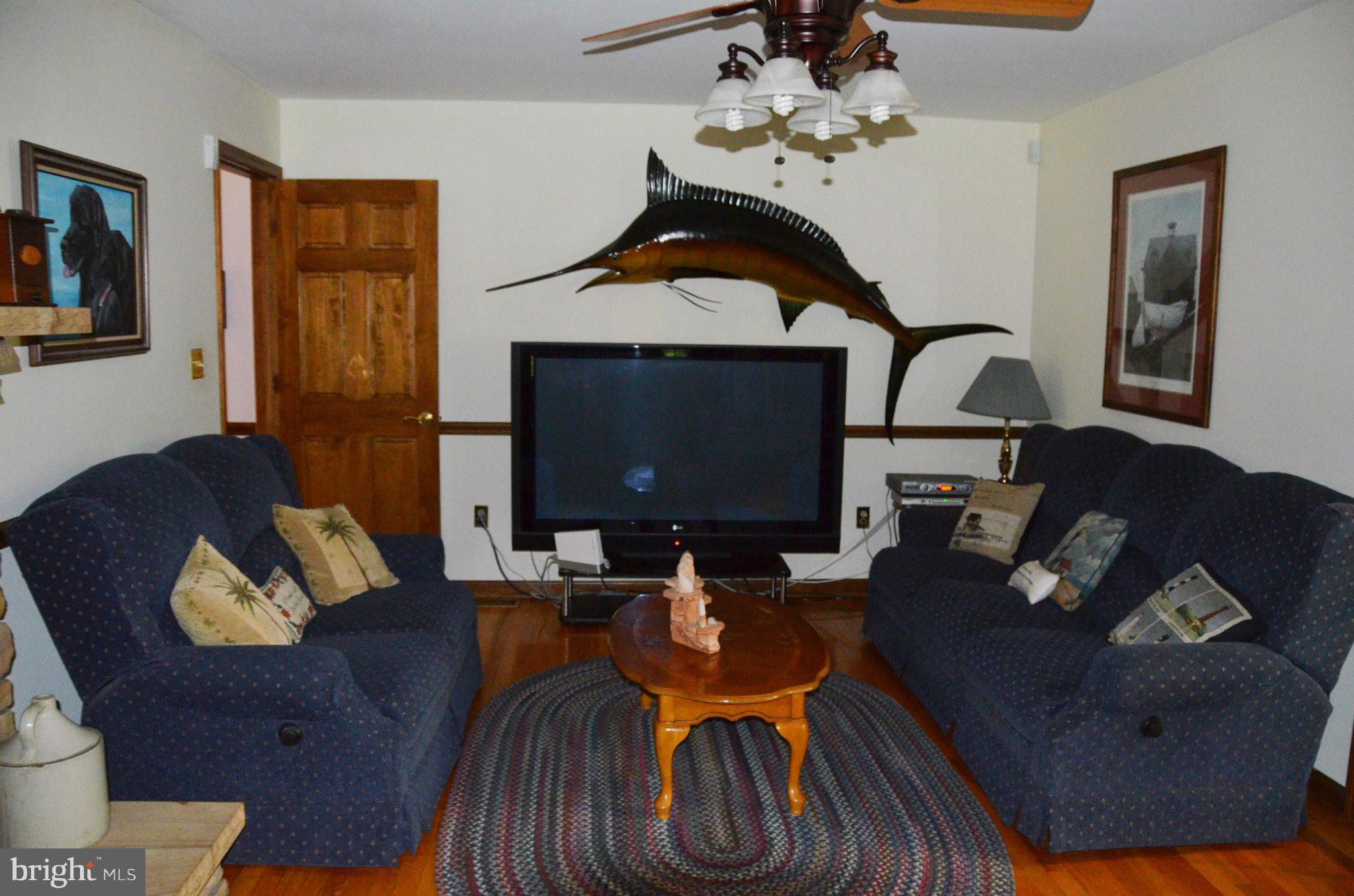 12717 Blair Road Lusby, MD 20657 - Photo 11 of 30 a living room with furniture chandelier and a fireplace