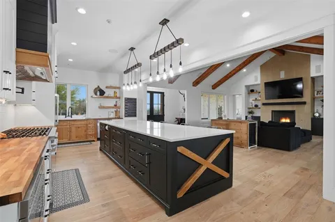 a large kitchen with stainless steel appliances kitchen island granite countertop a large counter top and a sink