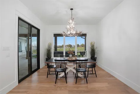 a dining room with furniture a chandelier and wooden floor