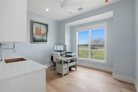 a view of a workspace with furniture and a window