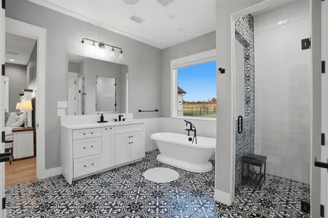 a spacious bathroom with a double vanity sink a toilet and a mirror