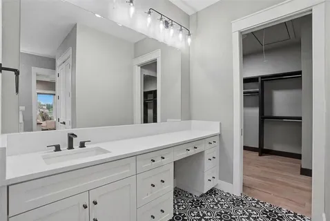a spacious bathroom with a double vanity sink a mirror and shower