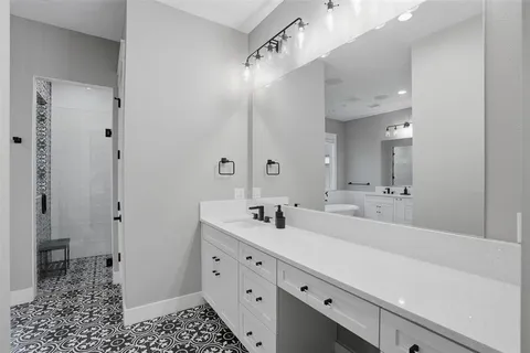 a bathroom with a double vanity sink a mirror and a shower