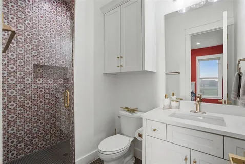 a bathroom with a sink a toilet and shower