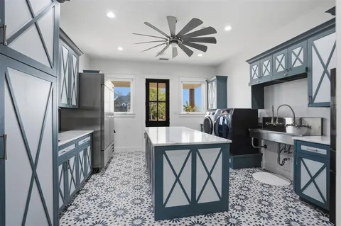 a kitchen that has a lot of cabinets in it and stainless steel appliances
